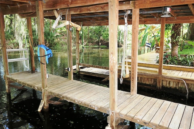 dock area with a water view and boat lift