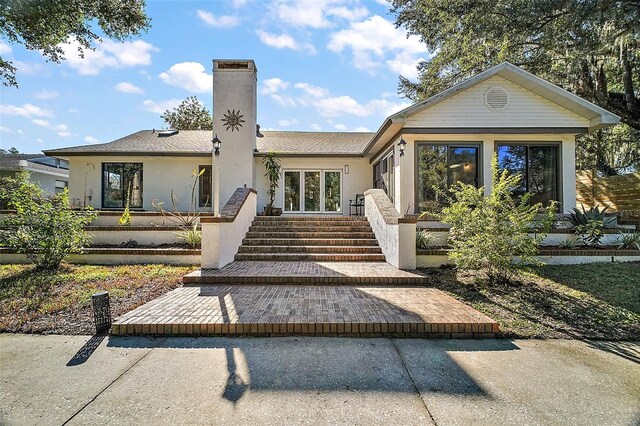 view of front of home featuring a chimney and stucco siding