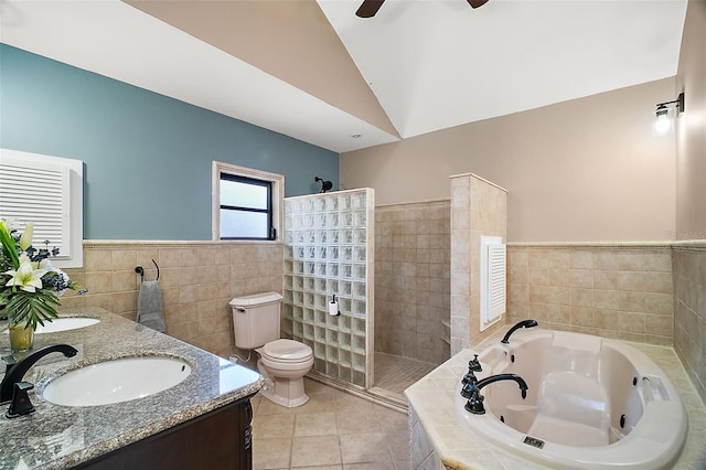 full bathroom featuring tile walls, separate shower and tub, vaulted ceiling, tile patterned floors, and toilet