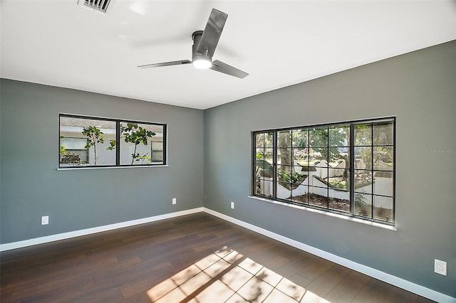 unfurnished room featuring a ceiling fan, visible vents, baseboards, and wood finished floors