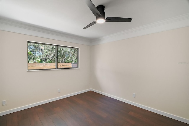 spare room with crown molding, dark wood finished floors, baseboards, and a ceiling fan