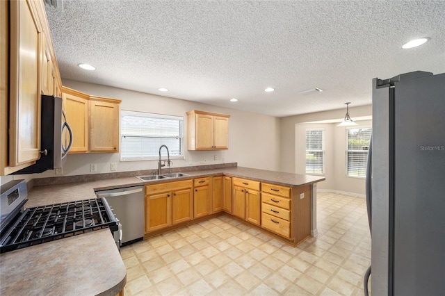 kitchen featuring pendant lighting, kitchen peninsula, stainless steel appliances, and plenty of natural light