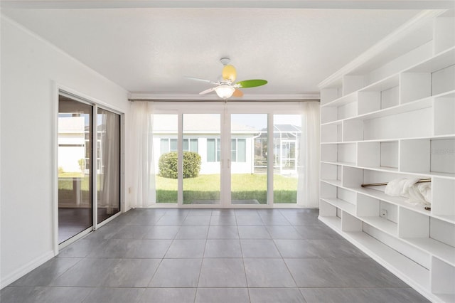 unfurnished sunroom featuring ceiling fan