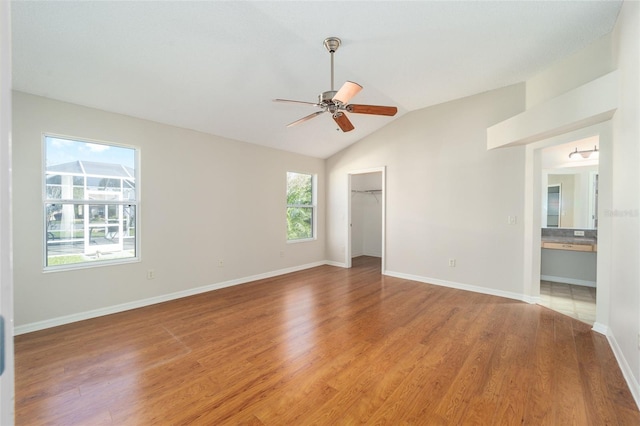 interior space featuring ceiling fan, wood-type flooring, and vaulted ceiling