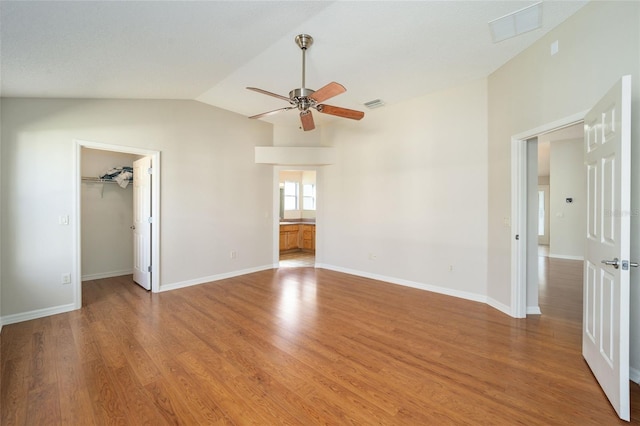 interior space with ceiling fan, wood-type flooring, and vaulted ceiling