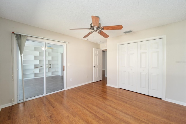 unfurnished bedroom featuring light hardwood / wood-style flooring, a textured ceiling, and ceiling fan