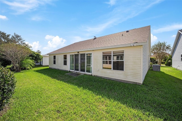 back of house featuring central air condition unit and a lawn