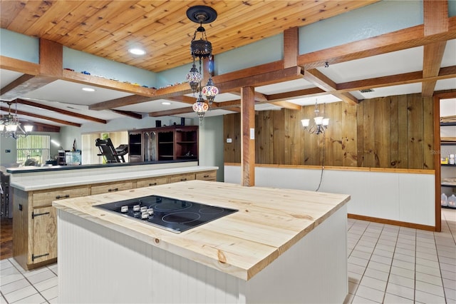 kitchen featuring decorative light fixtures, a kitchen island, an inviting chandelier, and black electric cooktop