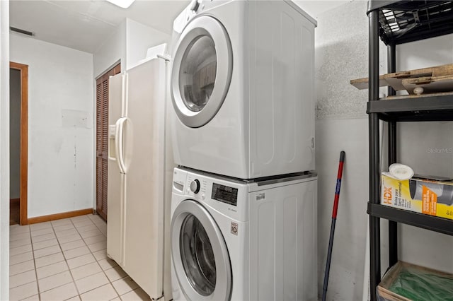 clothes washing area with light tile patterned floors and stacked washer / drying machine