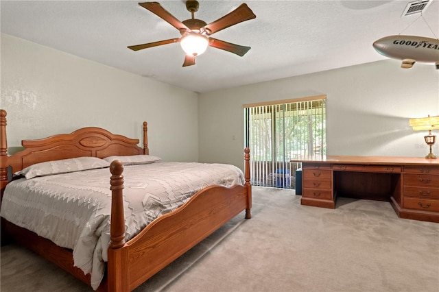 carpeted bedroom with a textured ceiling and ceiling fan