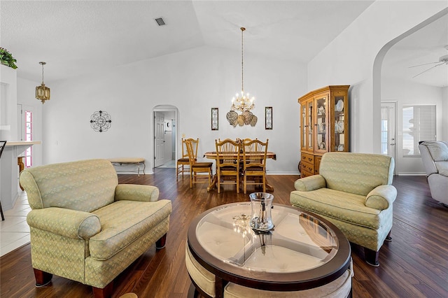 living room featuring ceiling fan with notable chandelier, lofted ceiling, and dark hardwood / wood-style flooring