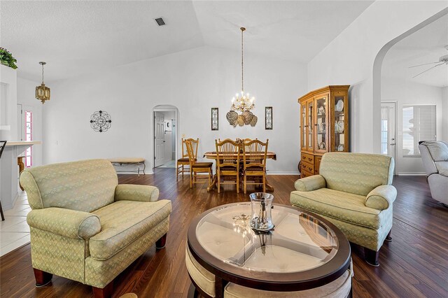 living room with visible vents, arched walkways, wood finished floors, vaulted ceiling, and a wealth of natural light