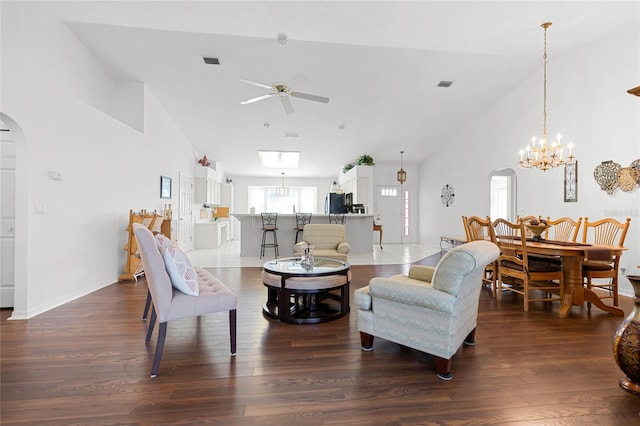 living room with ceiling fan with notable chandelier, dark hardwood / wood-style flooring, and high vaulted ceiling