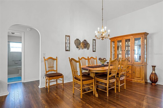 dining area with dark wood-type flooring and a chandelier