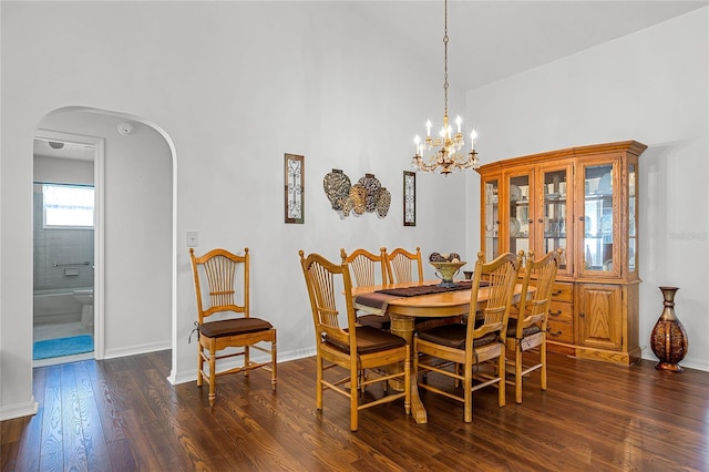 dining space with arched walkways, baseboards, dark wood finished floors, and a chandelier