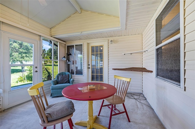 sunroom featuring plenty of natural light and vaulted ceiling with beams