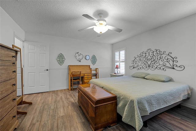 bedroom with a textured ceiling, ceiling fan, and hardwood / wood-style floors