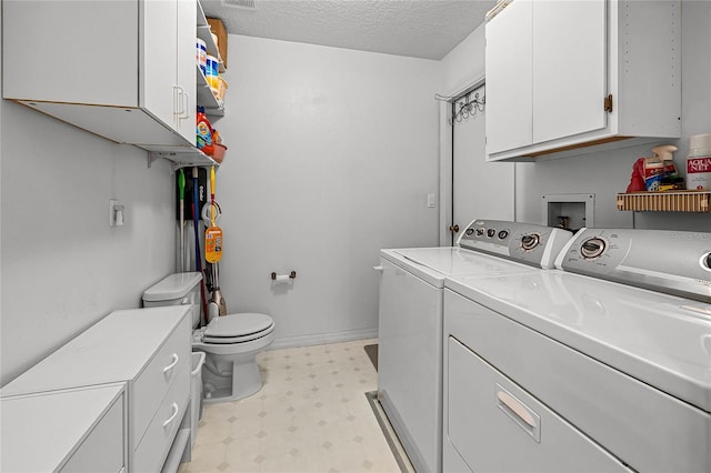 laundry area featuring a textured ceiling and washing machine and dryer