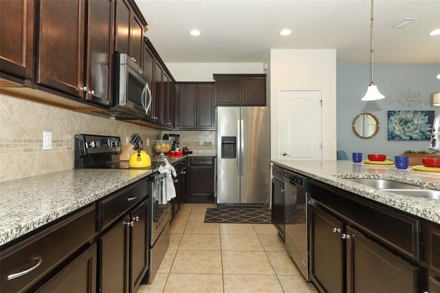 kitchen featuring light tile patterned floors, tasteful backsplash, hanging light fixtures, stainless steel appliances, and light stone counters