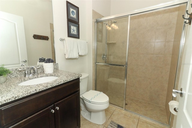 bathroom featuring a shower with shower door, tile patterned flooring, toilet, and vanity