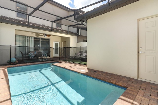 view of swimming pool with ceiling fan, a lanai, and a patio area