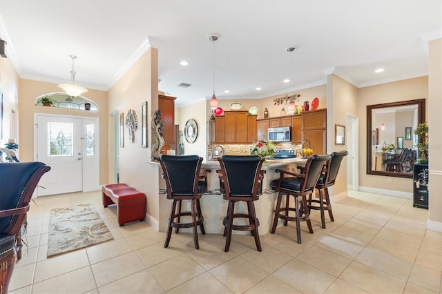 kitchen featuring light tile patterned floors, backsplash, hanging light fixtures, and crown molding