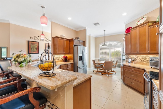 kitchen featuring a kitchen bar, backsplash, stainless steel appliances, crown molding, and decorative light fixtures