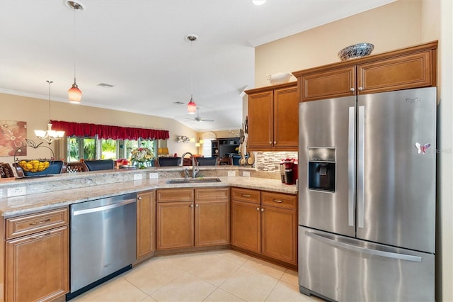 kitchen with backsplash, ceiling fan with notable chandelier, stainless steel appliances, sink, and decorative light fixtures