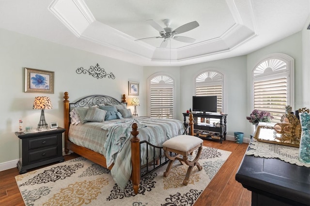 bedroom with a raised ceiling, ceiling fan, and light hardwood / wood-style flooring