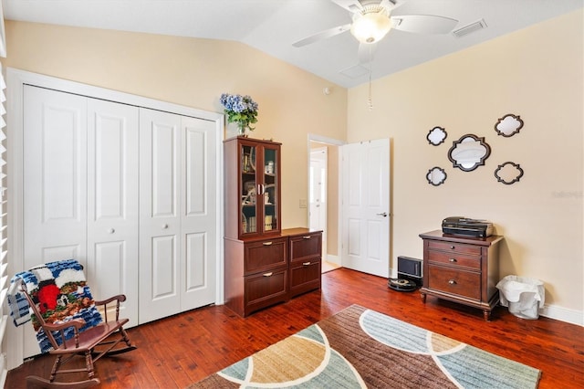 living area featuring lofted ceiling, ceiling fan, and dark wood-type flooring