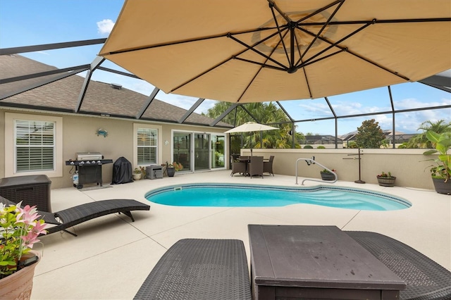 view of pool featuring glass enclosure, a patio area, and a grill