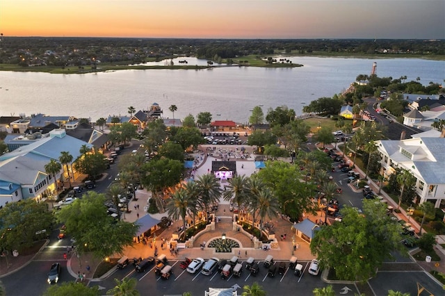 aerial view at dusk featuring a water view