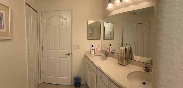 full bathroom with a closet, a sink, and double vanity