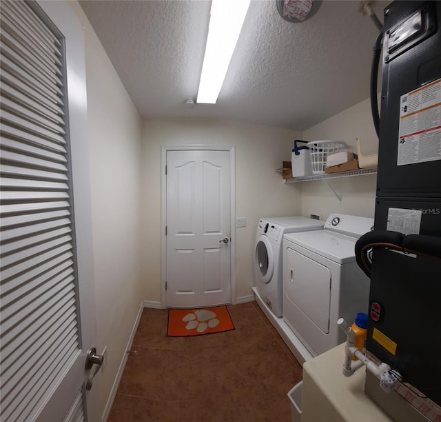 laundry room with laundry area, baseboards, a textured ceiling, and washing machine and clothes dryer