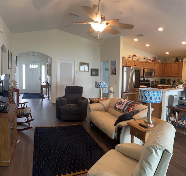 living area featuring arched walkways, dark wood-style flooring, and vaulted ceiling