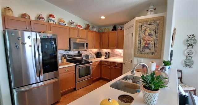 kitchen featuring recessed lighting, stainless steel appliances, a sink, light countertops, and backsplash