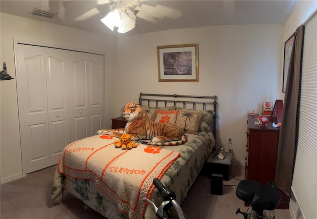 bedroom with a closet, carpet flooring, visible vents, and a ceiling fan