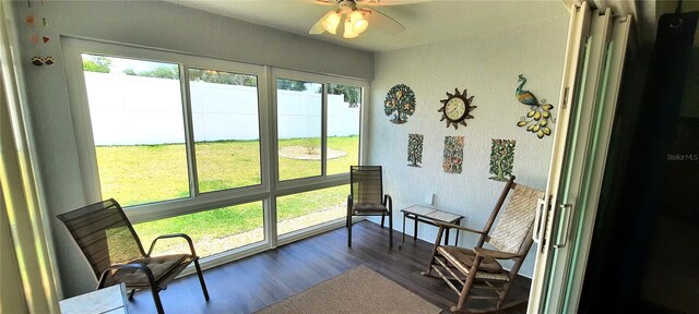 sunroom / solarium featuring a ceiling fan