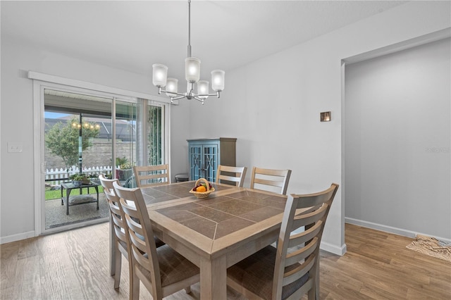 dining space with light wood-type flooring, a chandelier, and a healthy amount of sunlight