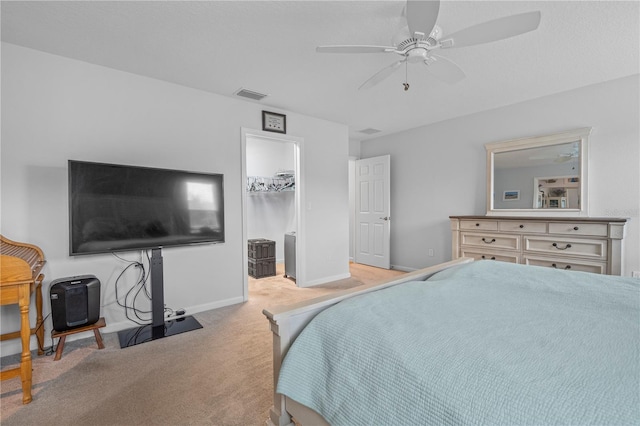 carpeted bedroom featuring a walk in closet, ceiling fan, and a closet