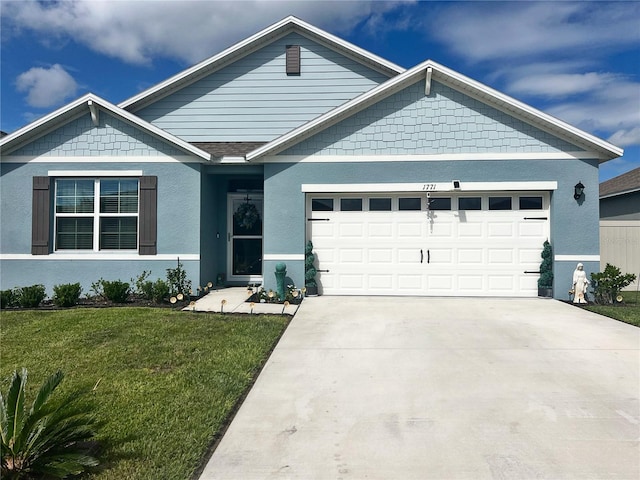 view of front of house with stucco siding, a front yard, an attached garage, and driveway