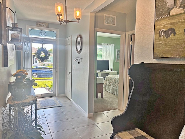 tiled foyer entrance featuring a healthy amount of sunlight and an inviting chandelier