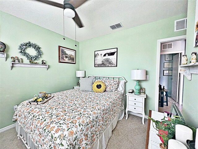 carpeted bedroom featuring ceiling fan and a textured ceiling