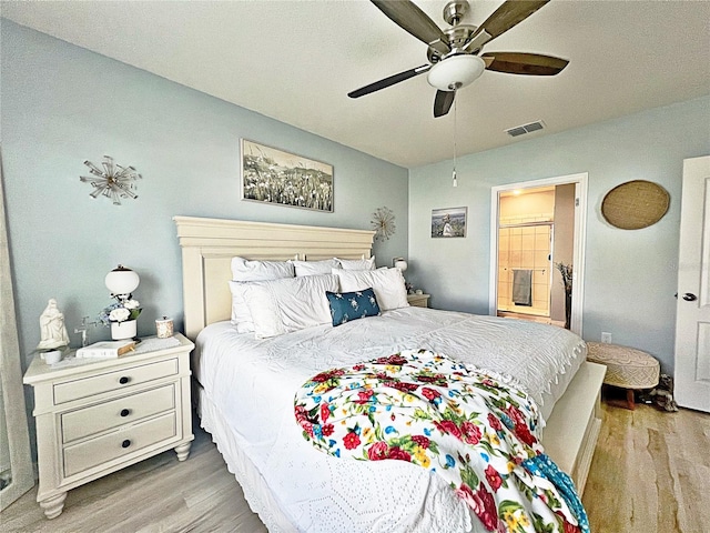 bedroom featuring ceiling fan, light hardwood / wood-style floors, and ensuite bathroom