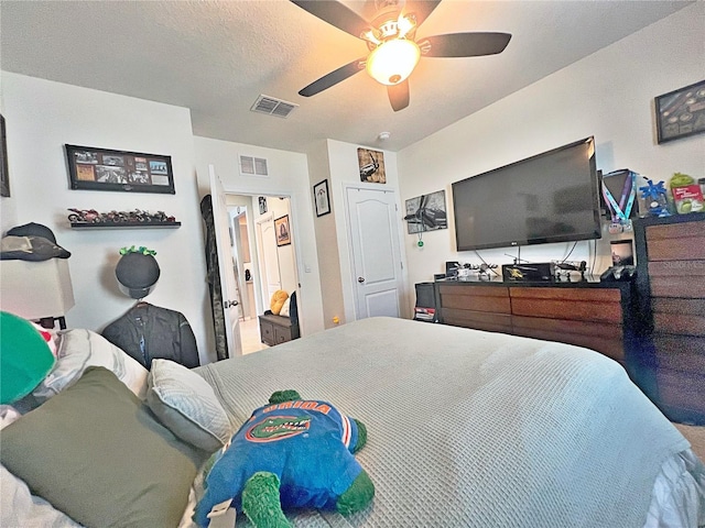 bedroom with a textured ceiling and ceiling fan