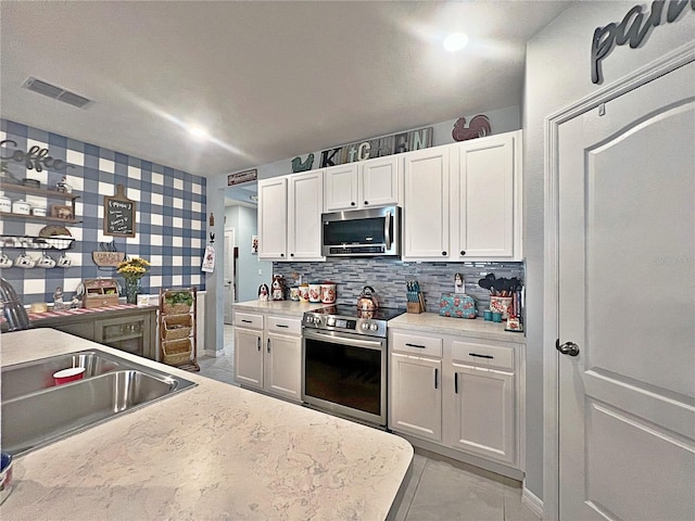 1771 Henin Cir, Tavares, FL 32778 - kitchen featuring a sink, white cabinetry, visible vents, and appliances with stainless steel finishes