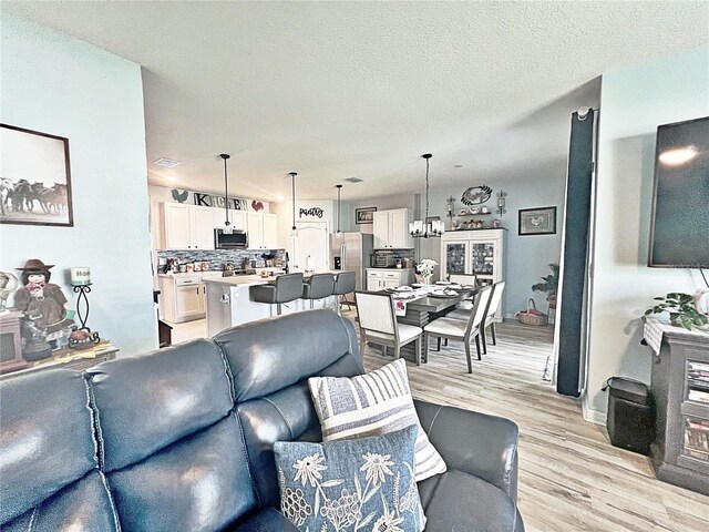 1771 Henin Cir, Tavares, FL 32778 - living room with light wood finished floors and a textured ceiling