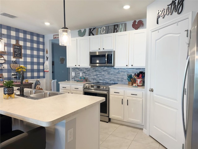 1771 Henin Cir, Tavares, FL 32778 - kitchen with wallpapered walls, white cabinets, light countertops, and appliances with stainless steel finishes