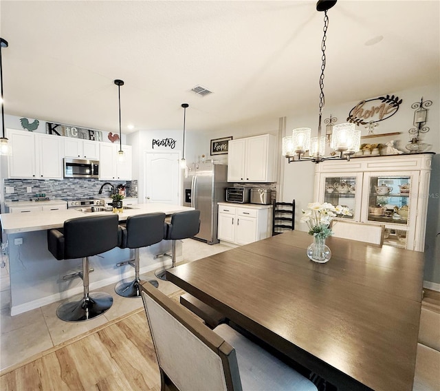 1771 Henin Cir, Tavares, FL 32778 - dining room featuring a toaster, visible vents, light wood-style floors, and a chandelier