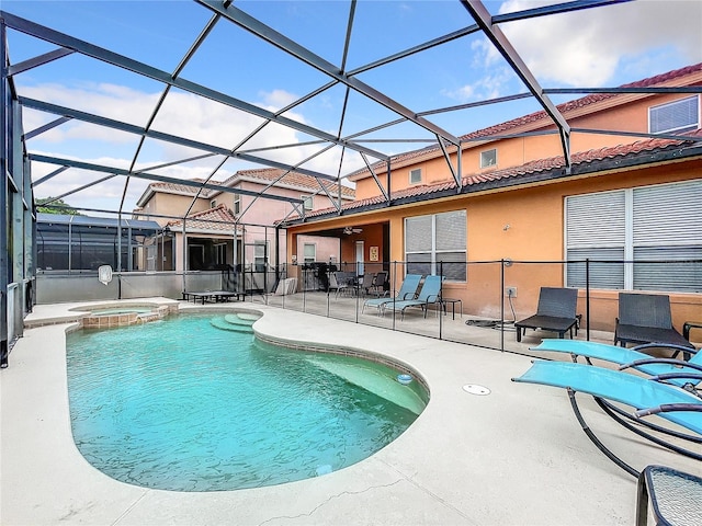 view of pool featuring glass enclosure, an in ground hot tub, and a patio